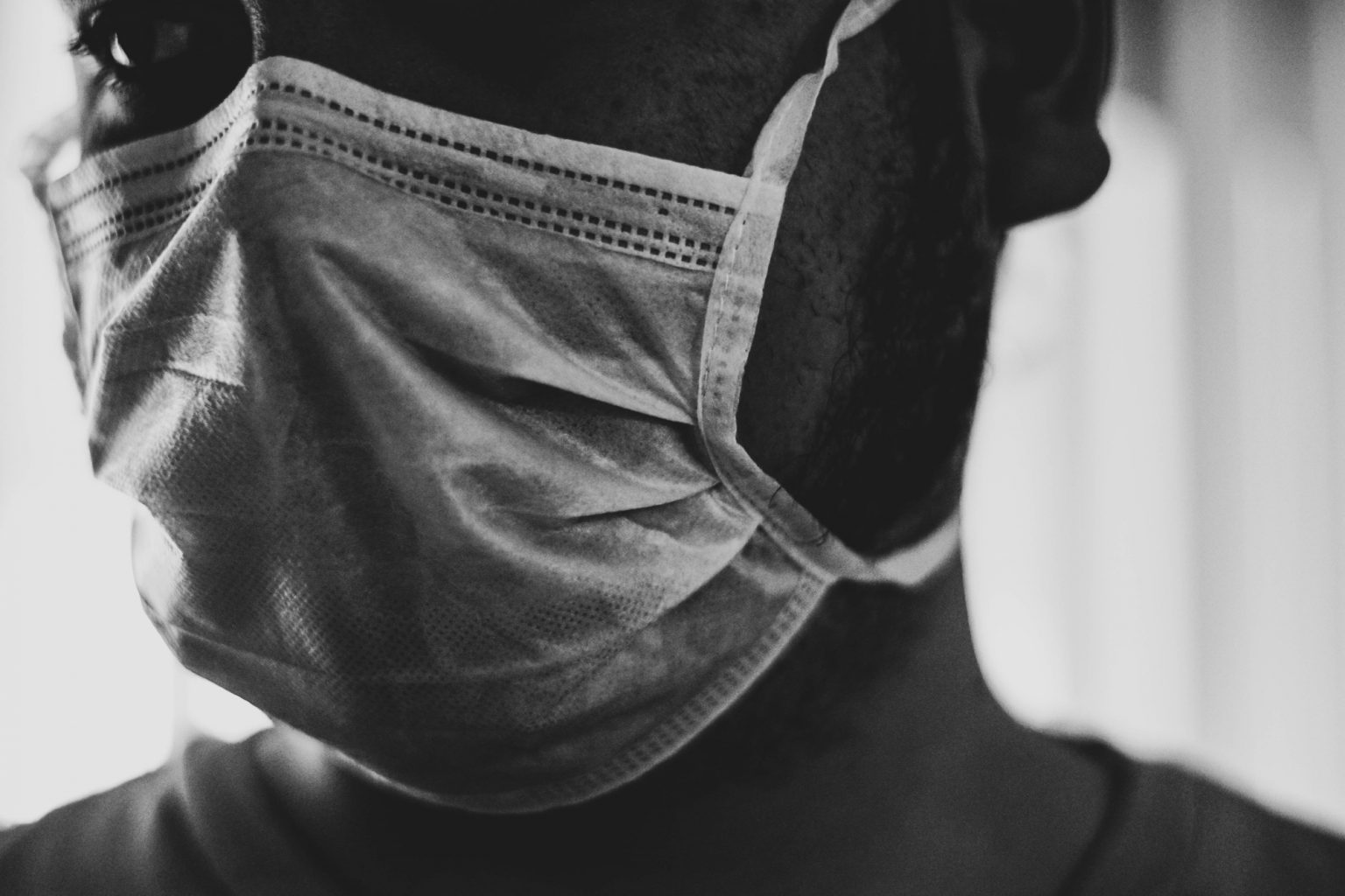 Black and white photo of man wearing facemask