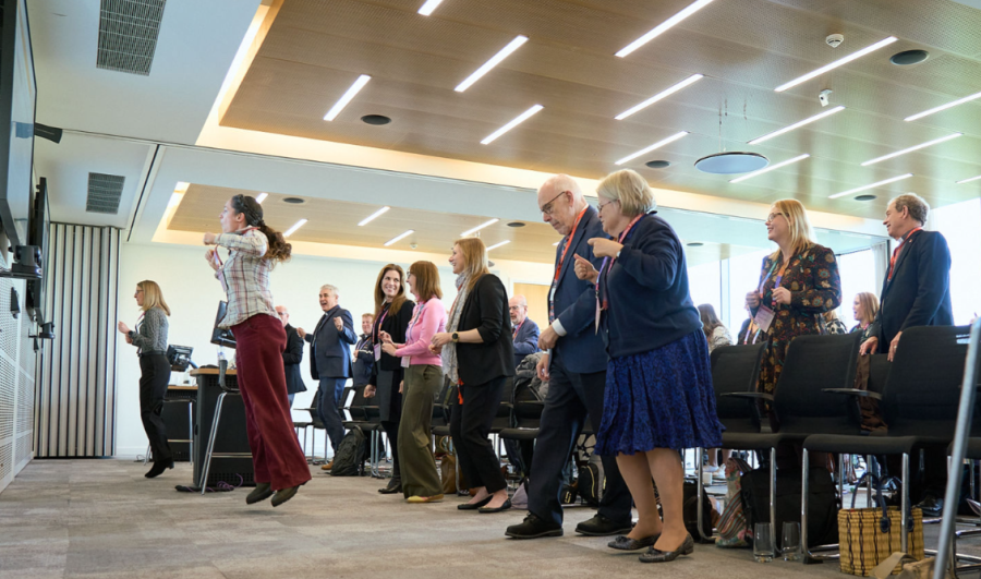 Conference attendees dance in unison in a demonstration led by Fischy Music.