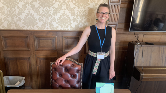 Stefanie at BIAPT, standing behind table covered in leaflets