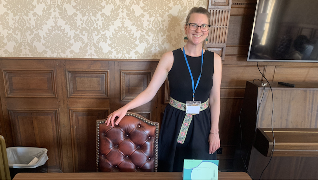 Stefanie at BIAPT, standing behind table covered in leaflets