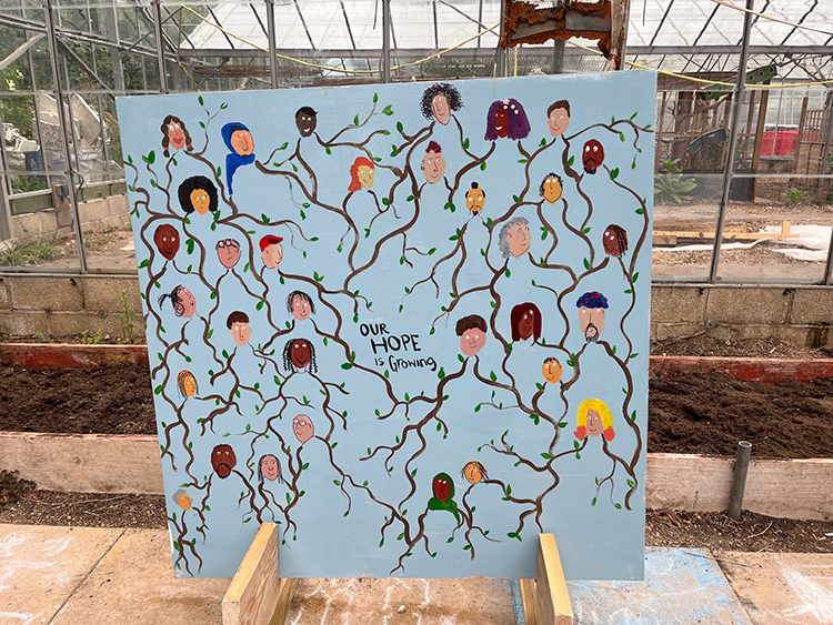 Large painted mural with tree branches and faces